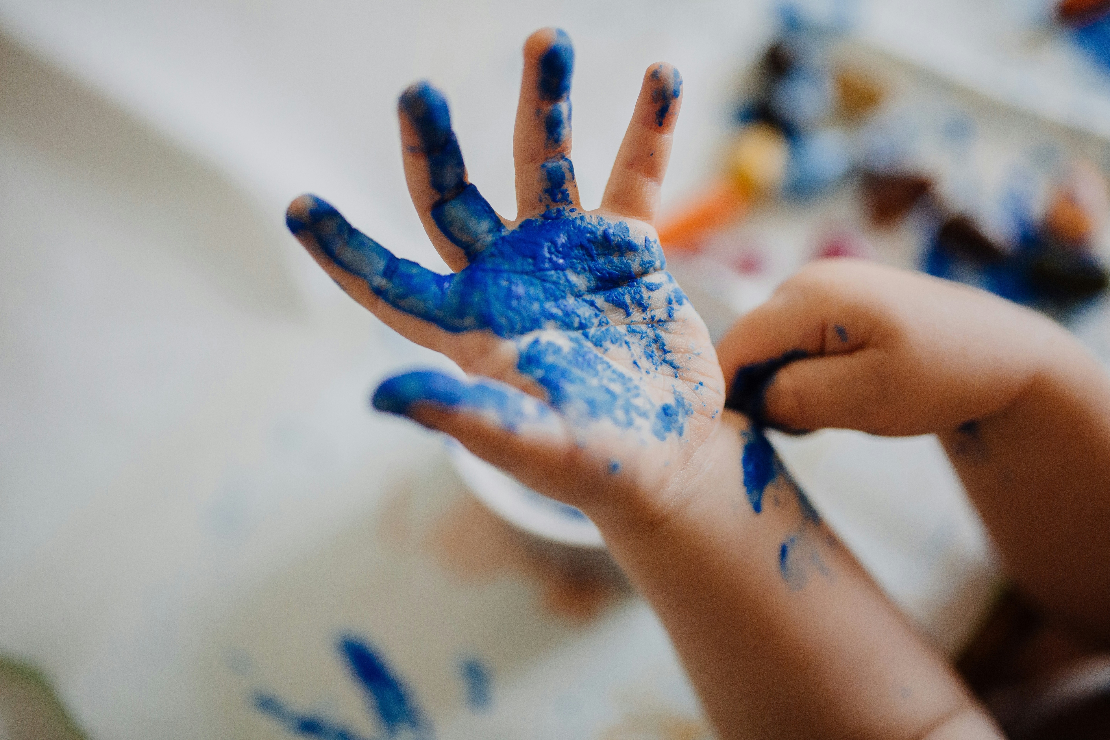 Kinderhand mit blauer Farbe